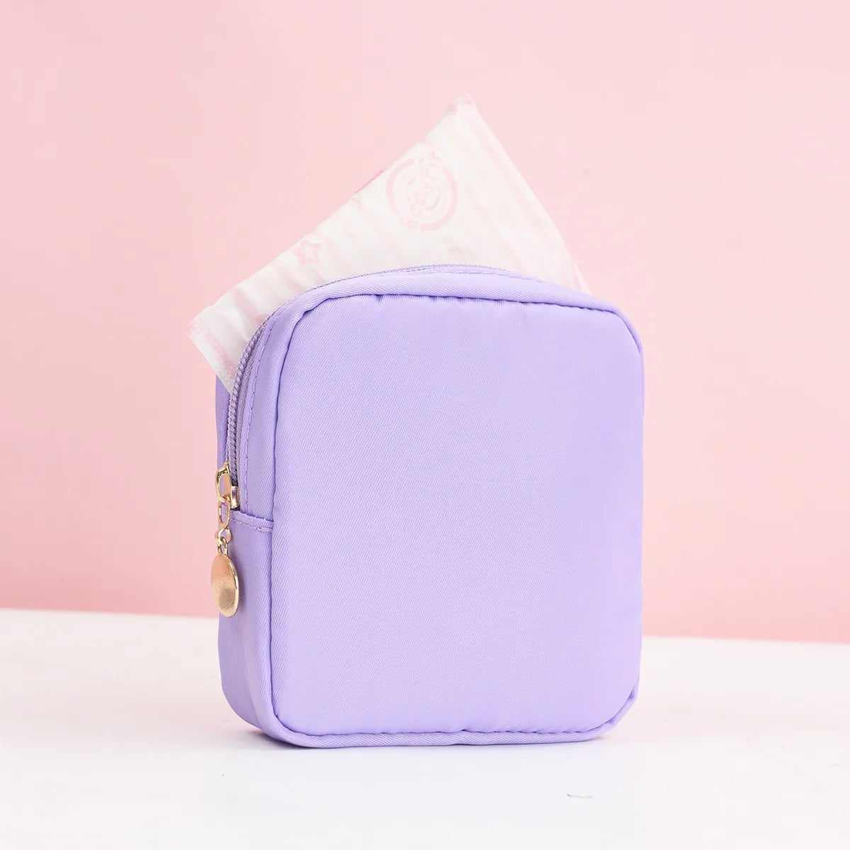 Lila tragbare Tasche für Damenbinden mit weißem Taschentuch darüber