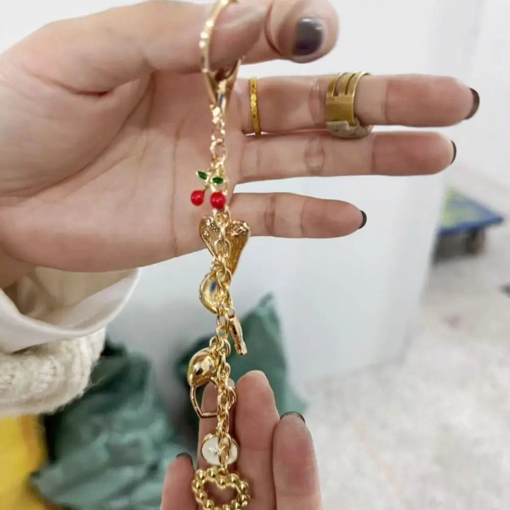 قلادة ميدالية بسلسلة ذهبية عليها تصميم عين حورس مع لمسات حمراء، تمسكها يد شخص.