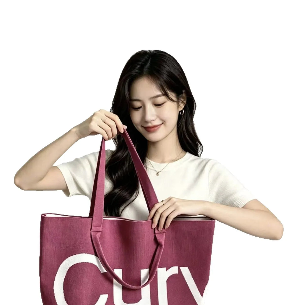 A woman holds a large knitted tote bag with a pink strap against a white background.