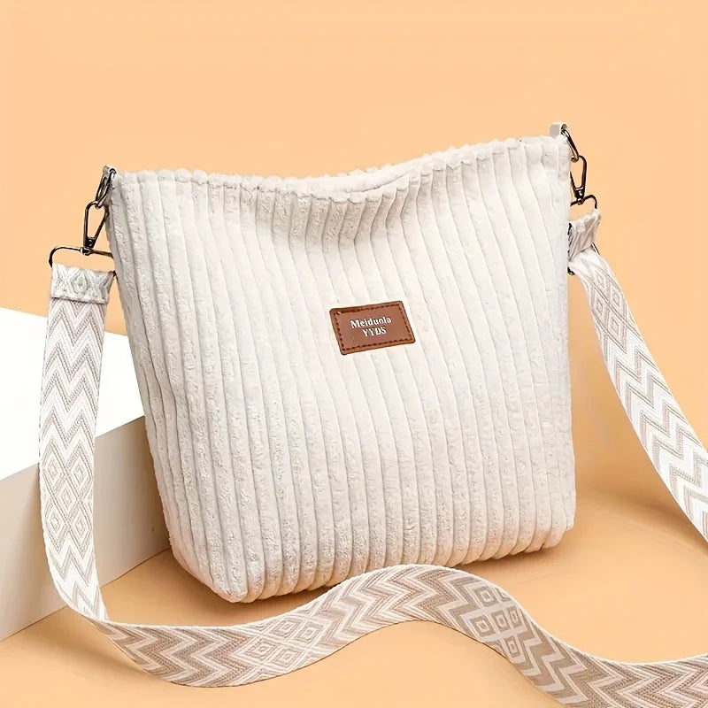 Sac à épaule et bandoulière en velours côtelé de couleur crème pour femme avec une sangle à motifs.