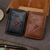 A pair of vintage brown and black PU leather slim wallets with embossed initials resting in a wooden box.
