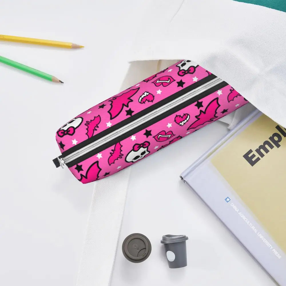 A pink and black zippered pencil case decorated with pink and white animal silhouettes is shown next to a notebook and pencil