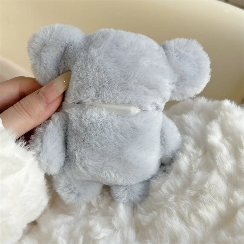 A soft gray plush elephant toy is being held in a white fluffy material.