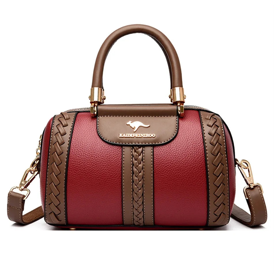 A maroon leather shoulder bag with gold hardware and a woven pattern on the front.