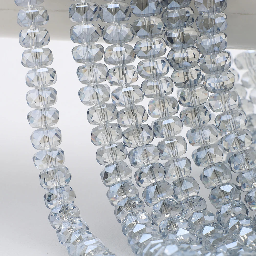 Close-up of clear faceted crystal glass beads in a wheel shape strung together for jewelry making