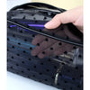 A hand is opening a black mesh transparent makeup storage bag, revealing purple light inside.
