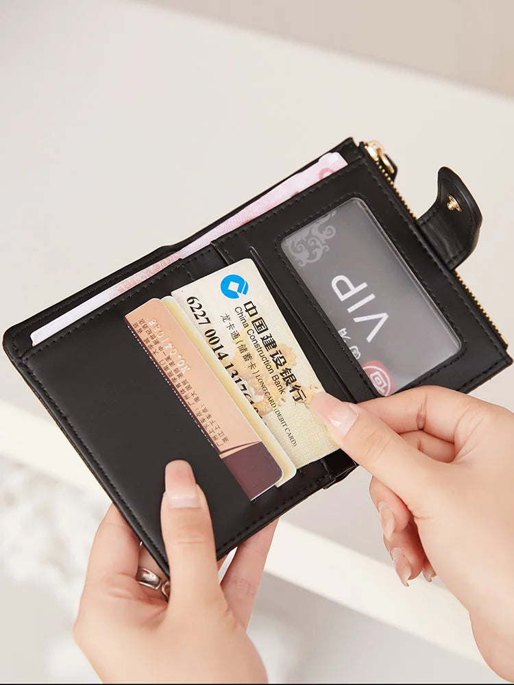 A hand holds a black PU leather bifold wallet with a zipper closure, displaying an ID card.
