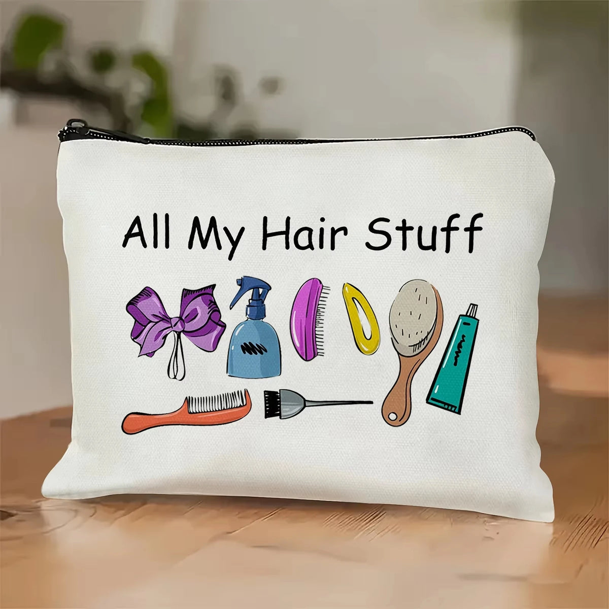 A white zippered pillow features a graphic illustration of various hair tools and accessories.