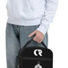Eine Frau hält eine schwarze wiederverwendbare Oxford-Lunchtasche mit einem weißen Hoodie.