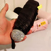 A hand holds a black compact umbrella with a rhinestone sphere and pink fabric, labeled for UV protection.