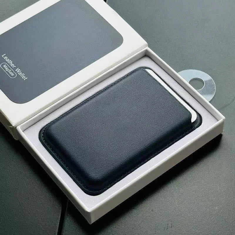 A dark gray leather wallet case is displayed inside its white box with a MagSafe accessory.