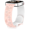 Una correa de silicona blanca con estampado floral rosa, adjunta a un Apple Watch.