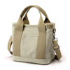 A beige canvas crossbody bag with adjustable straps and multiple pockets.