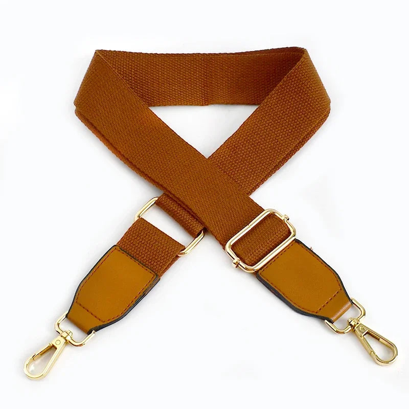A brown canvas cotton bag strap with gold-toned metal hooks, shown in an X-shape.