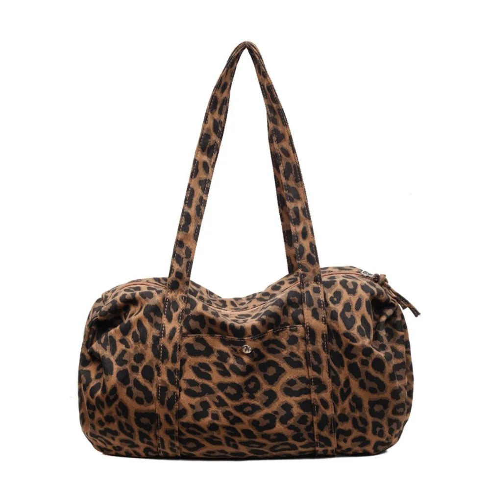 A brown leopard print canvas tote bag with an adjustable shoulder strap.