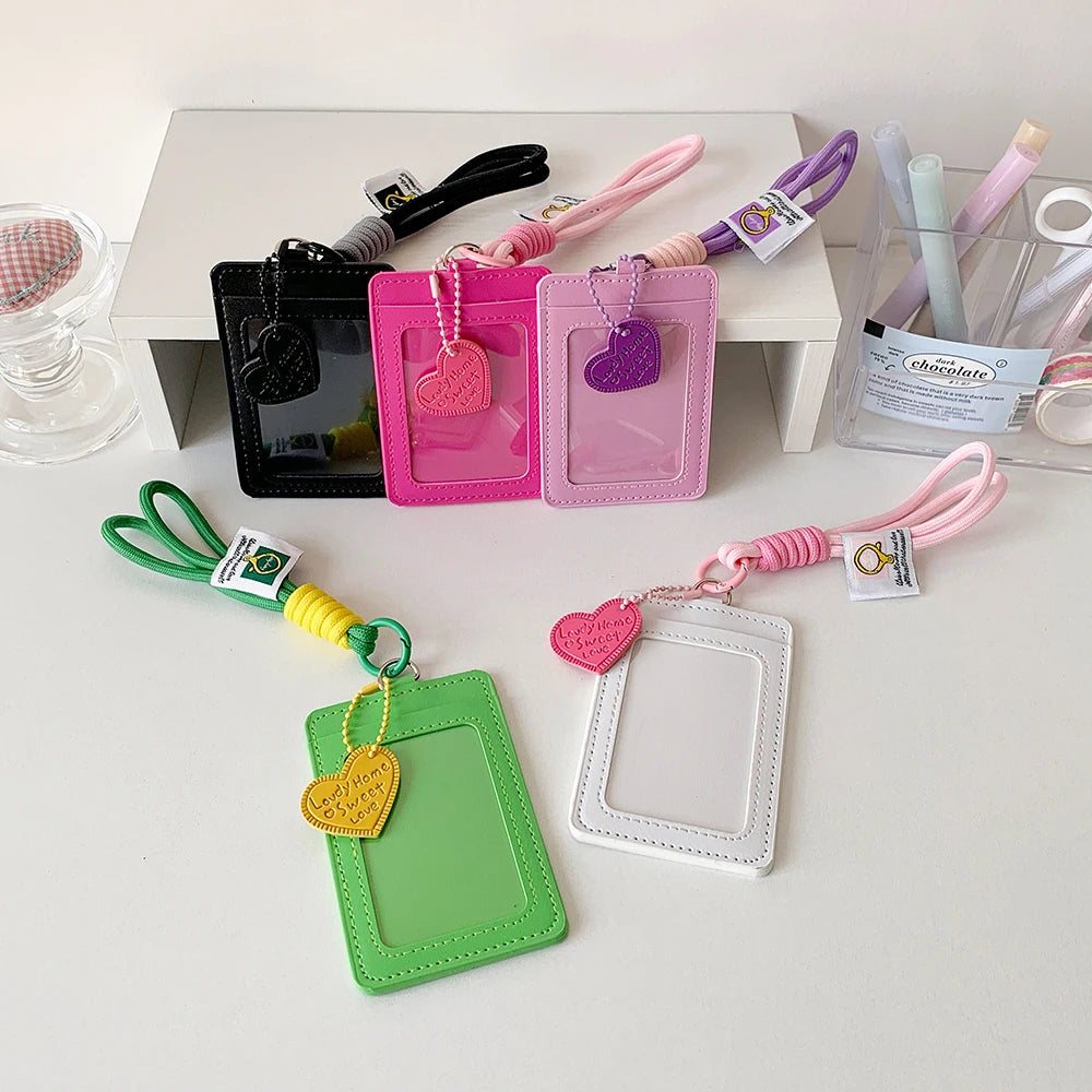 A collection of pink, green, and purple PU credit card and ID holder keychains with various colored cord lanyards.