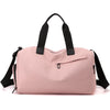 A pink waterproof travel duffle bag with black straps and a separate shoe compartment.