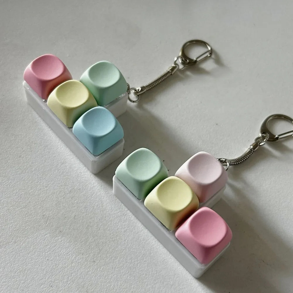 A white tactile stress relief keyboard fidget toy with colorful silicone keys and metal chain.