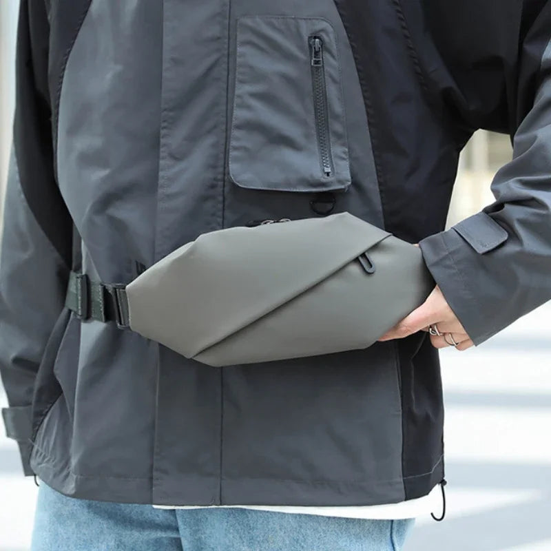 Graue minimalistische Lauf-Tauschtasche, befestigt an einer dunkelgrauen Jacke.