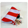 Pochette en tissu rayé rouge et blanc avec divers produits cosmétiques à l'intérieur.