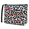 Bolsa de cosméticos con estampado de leopardo en blanco y negro y correa negra.