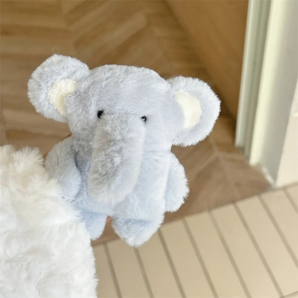 A light blue plush elephant toy is visible in a soft indoor setting.