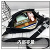 A black plaid crossbody chest bag is shown open, displaying various small items like a watch, cosmetics, and a wallet.