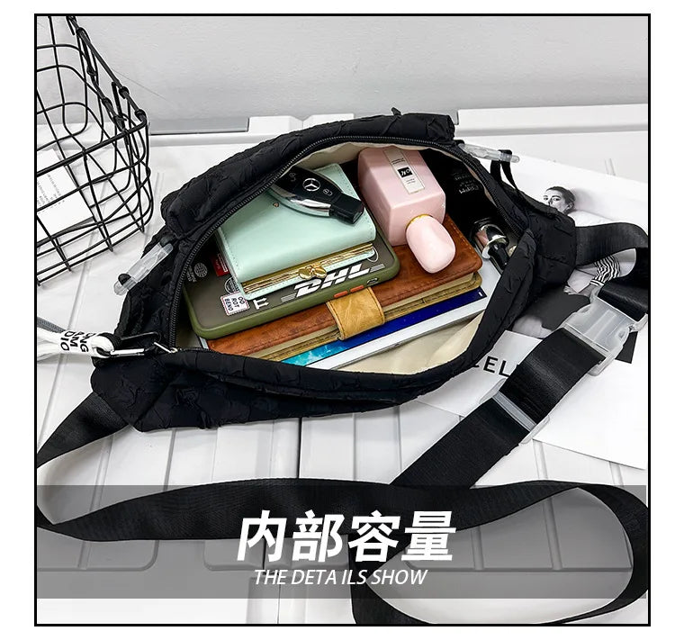 A black plaid crossbody chest bag is shown open, displaying various small items like a watch, cosmetics, and a wallet.