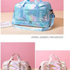 A light blue iridescent nylon travel bag with pink accents is displayed on a beige surface.