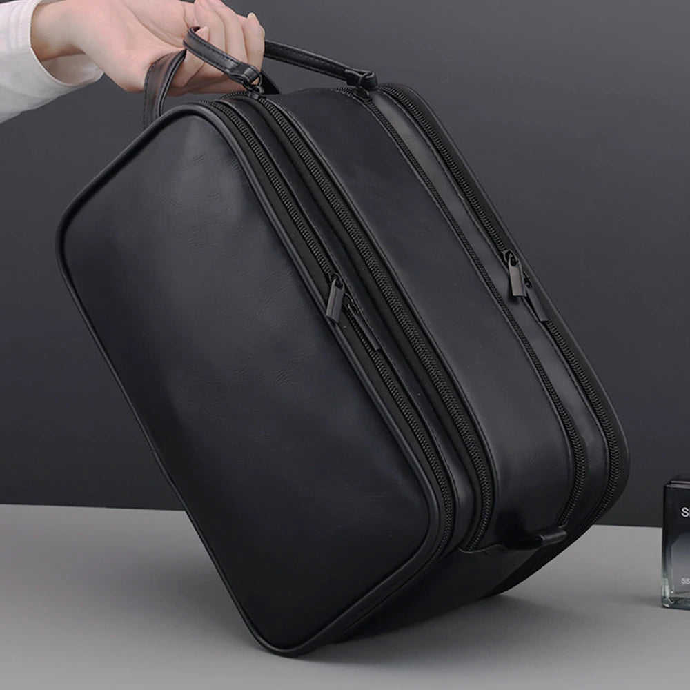 Un sac de toilette de voyage en cuir PU noir et premium tenu à la main.