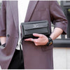Une personne tient un porte-monnaie à pochette en PU brun foncé avec une fermeture éclair double sur le revers d'un manteau t
