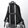 A black men's ultralight waterproof laptop backpack resting on a silver suitcase.