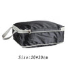 A black reusable compression packing cube with a light gray zipper and strap.