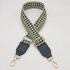 A beige and olive green checkered braided nylon bag strap with metal hooks.