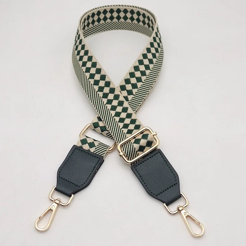 A beige and olive green checkered braided nylon bag strap with metal hooks.