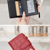 A close-up of a black minimalist PU leather bi-fold wallet with an ID window and a red quilted leather wallet.