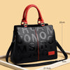 Sac bandoulière en cuir PU noir avec poignée rouge et texte gravé sur le devant.