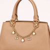 Helle beige Leder-Crossbody-Tasche mit goldfarbener Kette und Perlenblumen.