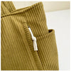 Close-up of a mustard green corduroy casual handbag with a white drawstring detail.