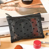 A black mesh cosmetic storage pouch with a zipper is displayed on a wooden surface next to skincare products.