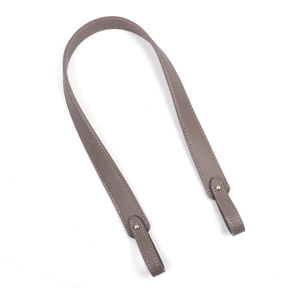 Gros plan d'une sangle de sac à main en cuir PU beige avec des éléments métalliques dorés.