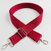 A red woven strap with an arrow jacquard pattern and silver hardware.