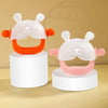 A set of silicone teethers shaped like cute bunnies in white and orange colors displayed on a light wooden surface.