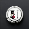 A silver foldable letter hanger hook with the letter U embossed on it, set against a dark background.