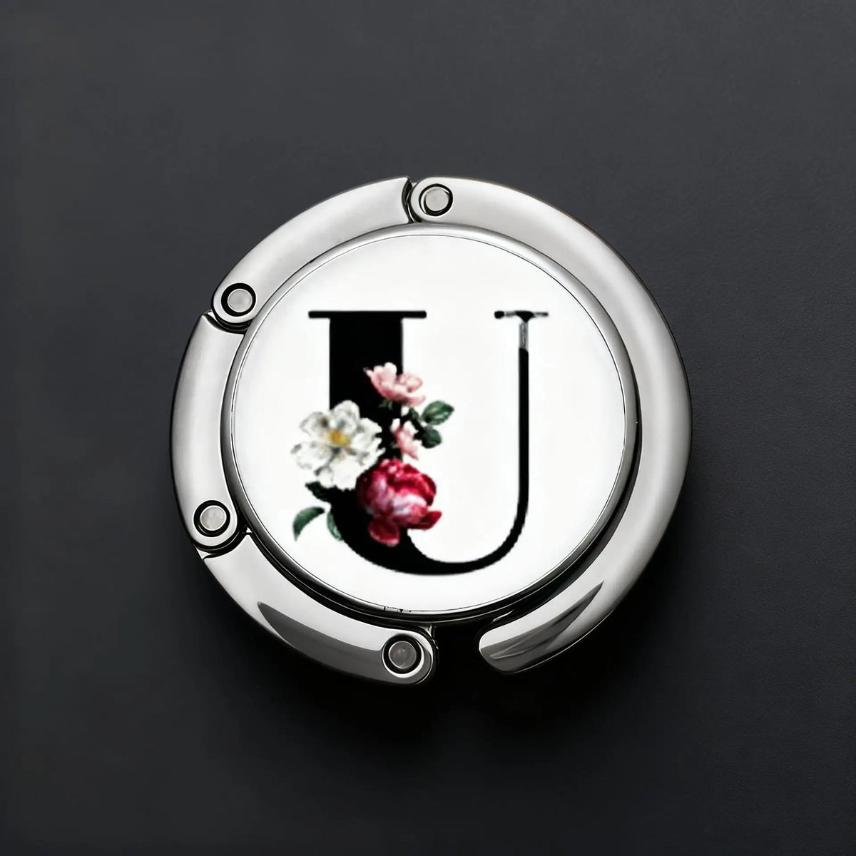 A silver foldable letter hanger hook with the letter U embossed on it, set against a dark background.