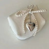 A pearl bowknot keychain featuring a heart charm, displayed on a white surface.