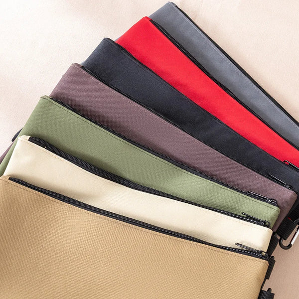 A stack of multi-functional organizer tool kit bags in various colors including red, gray, olive green, and beige.