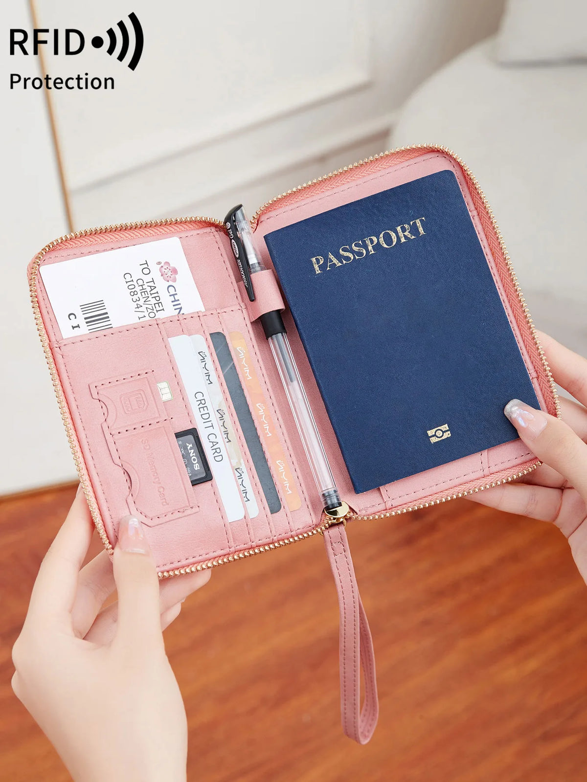A hand opens a pink RFID-blocking passport wallet showing various documents and a passport inside.
