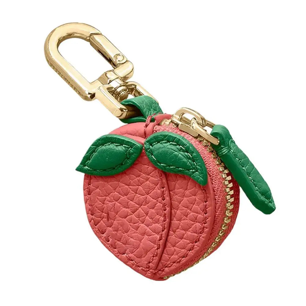 Pinkes strukturiertes Frucht-Charm-Münztaschen-Anhänger mit grünem Stoff und goldfarbener Schnalle.