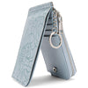 A light blue leather zip coin purse with a floral embossed design and a silver key ring.